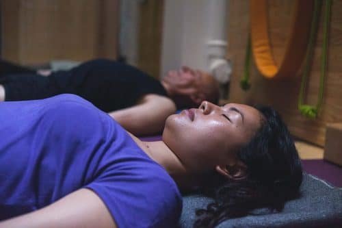 Élèves allongés en Shavasana dans une séance de yoga restauratif Iyengar